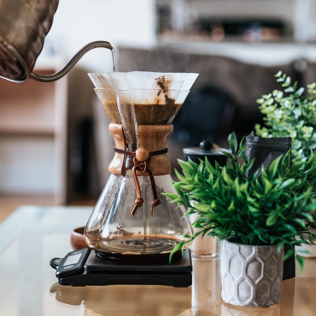 café versé dans une cafetière posée sur une table.